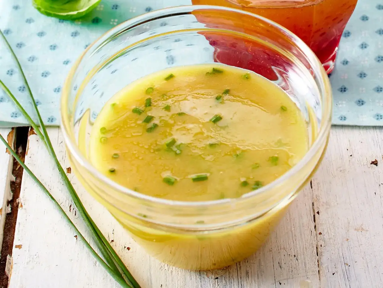 Ein Glas mit cremigem honig senf dressing, garniert mit Schnittlauch. Perfekt f&uuml;r Salate.