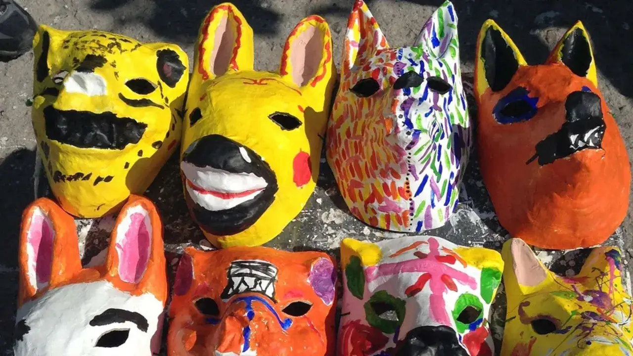 Bunte Pappmaché-Masken von Tieren, die an Luftballons erinnern, warten auf ihre Träger.