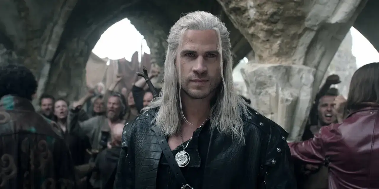 Geralt z Rivii w czarnej zbroi, z wilczym medalionem, stoi przed wzburzonym tłumem. Zapowiada się gorący wiedźmin sezon 3.