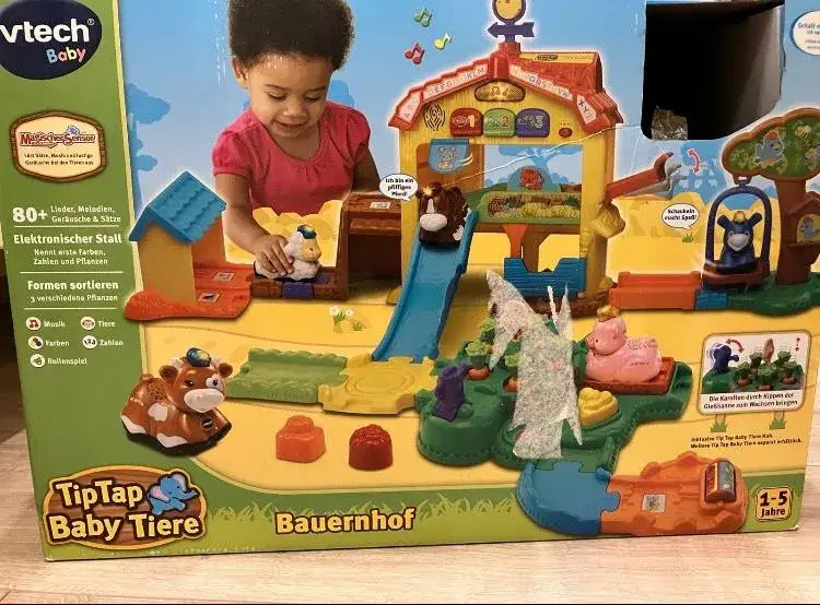 Kleinkind spielt mit Tieren auf Bauernhof