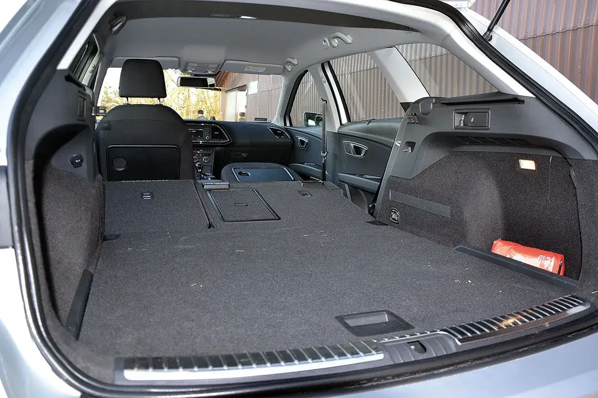 Wnętrze kombi Seat Leon Sportstourer z rozłożonymi tylnymi siedzeniami, tworzącymi dużą przestrzeń bagażową.