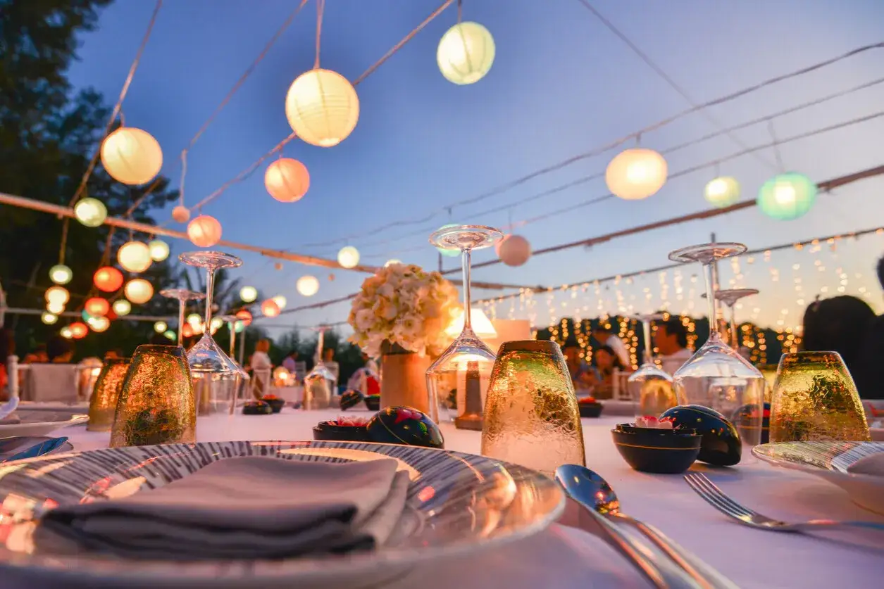 Festlich gedeckter Tisch mit Kerzen und Lampions, perfekte gartenhochzeit deko f&uuml;r eine romantische Feier im Freien.