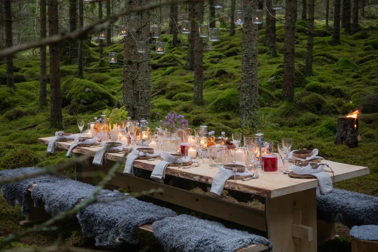 En magisk skogsmåltid med levande ljus och fårskinnsklädda bänkar. En perfekt plats för unika upplevelser i Sverige.