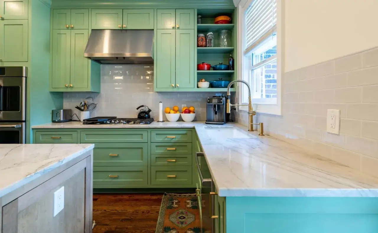 Encantadora cocina con gabinetes verde menta y encimeras de mármol. Una excelente combinacion colores para cocina, con toques dorados en los tiradores y grifería.
