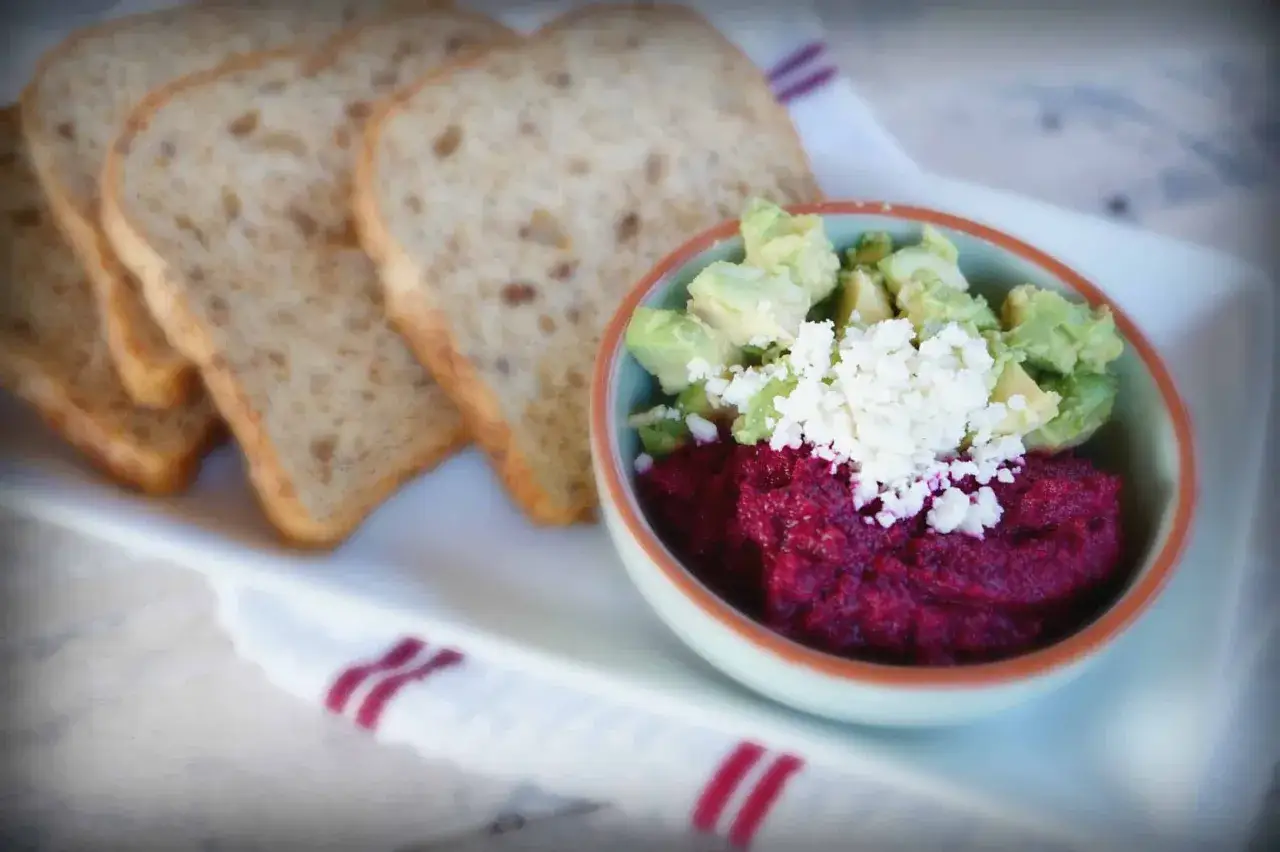 Rote Bete Aufstrich vegan mit Avocado und Feta auf Vollkorntoast.