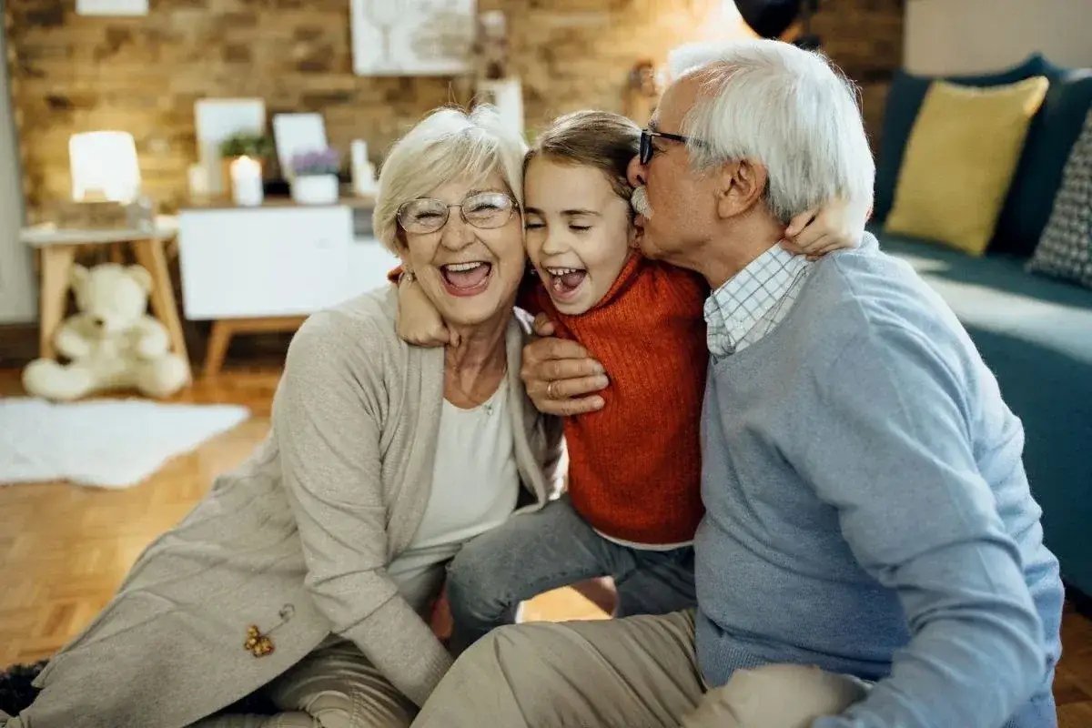 Nonni felici abbracciano la nipote, un'immagine che celebra il diritto dei nonni a vedere i nipoti e l'amore che li lega.