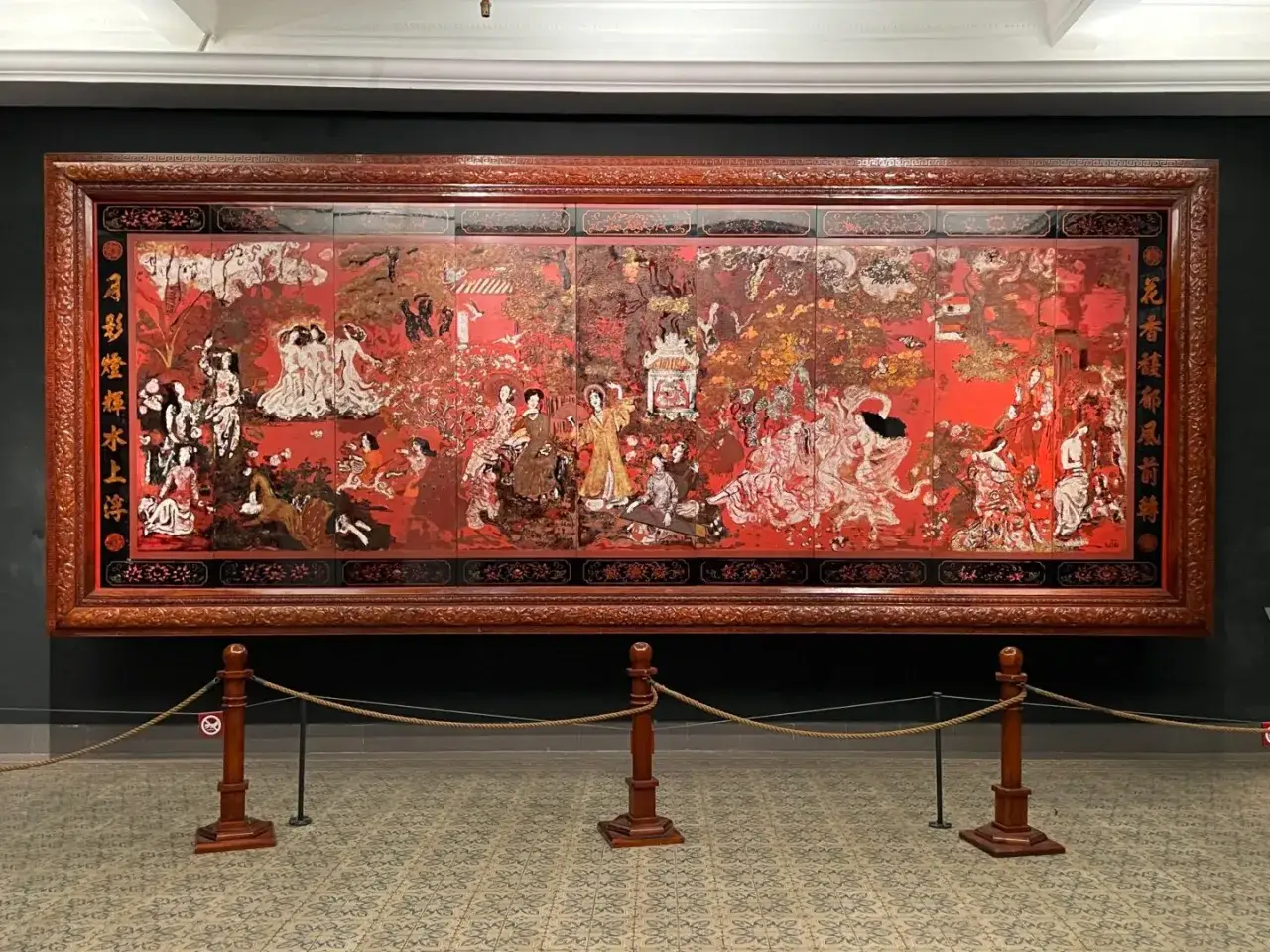 A vibrant, multi-panel artwork by asian artists depicts a lively scene with figures in flowing robes amidst trees and architecture.