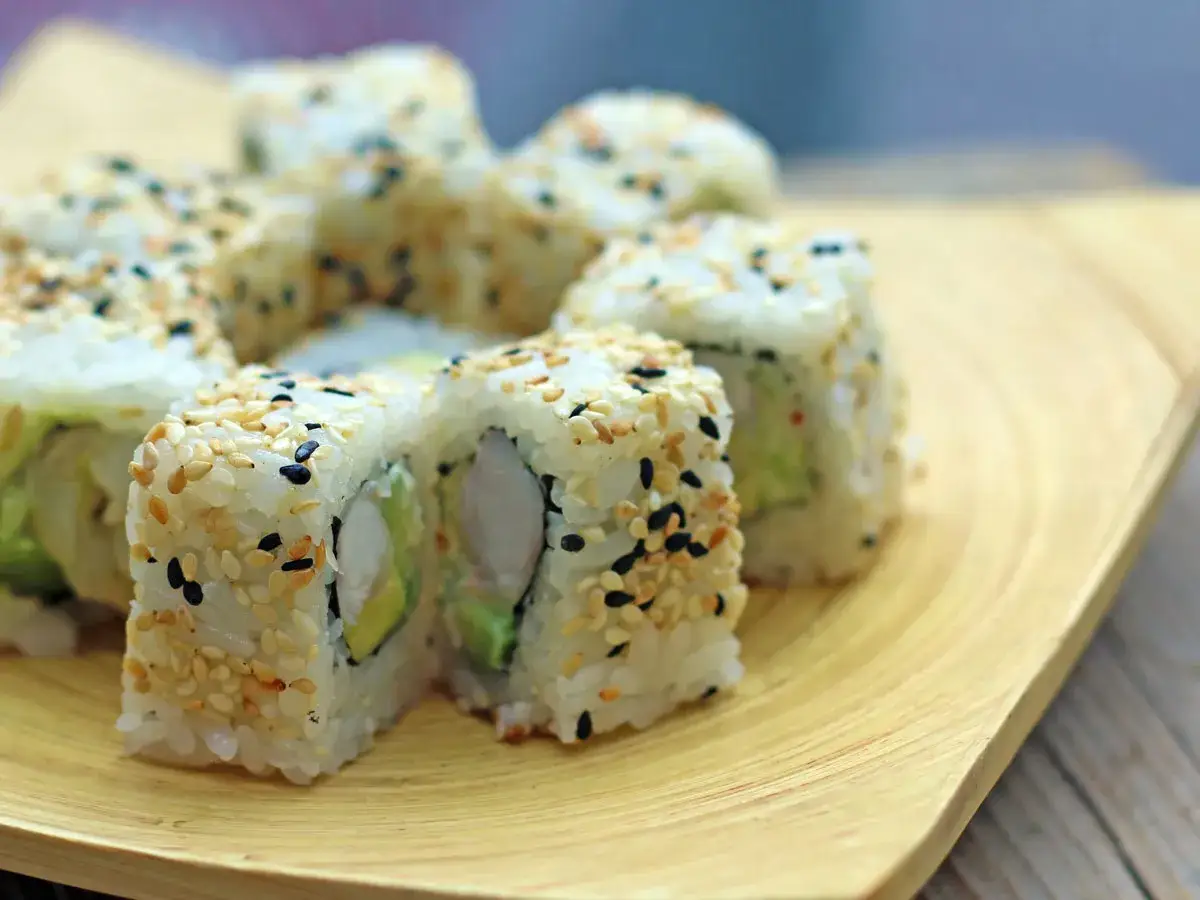 Uramaki z sezamem i awokado, pyszne rolki sushi, które kuszą smakiem i wyglądem.