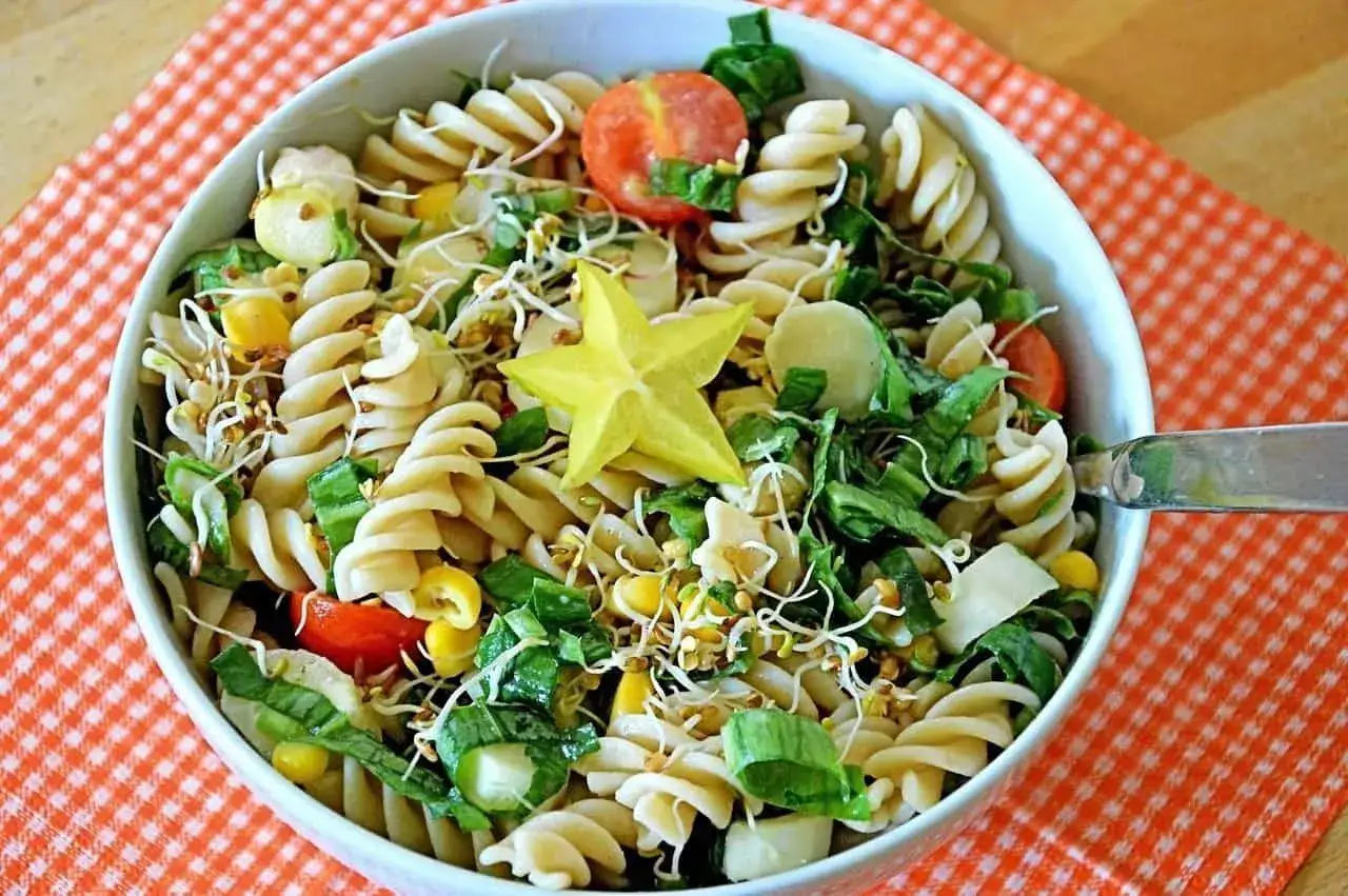 Unas ensaladas de pasta vibrantes y frescas, llenas de maíz, brotes y una estrella de carambola.