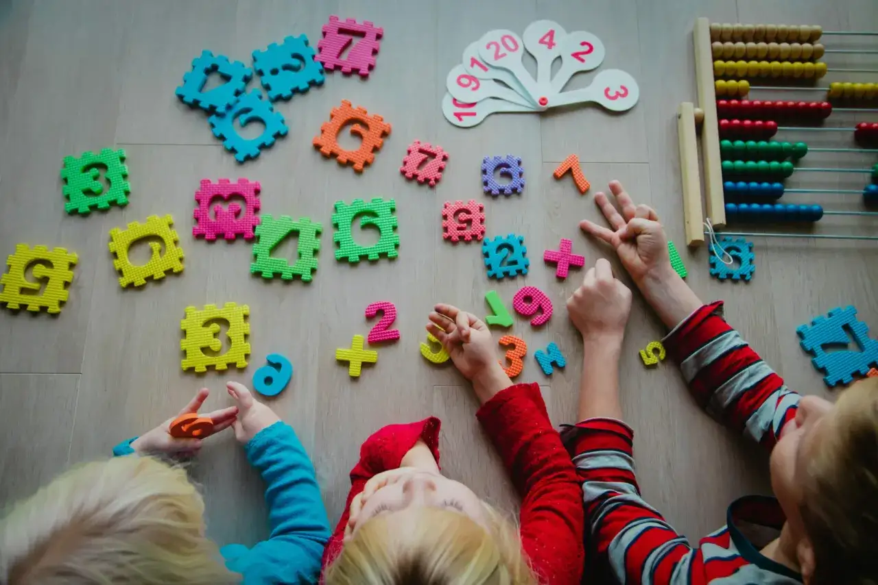 Kinderen ontdekken de **wereld van getallen** met kleurrijke puzzelstukjes en een telraam.