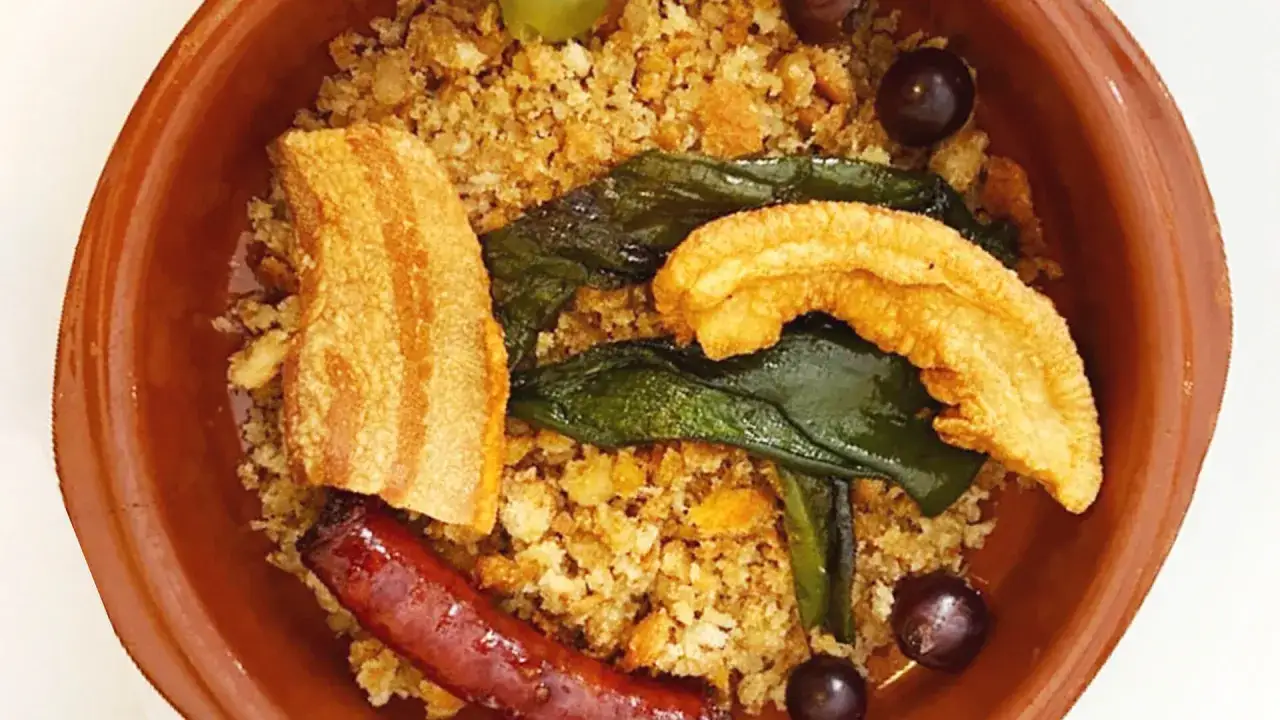 Plato de migas con chorizo, torreznos y uvas, típico de los mesones riopar.