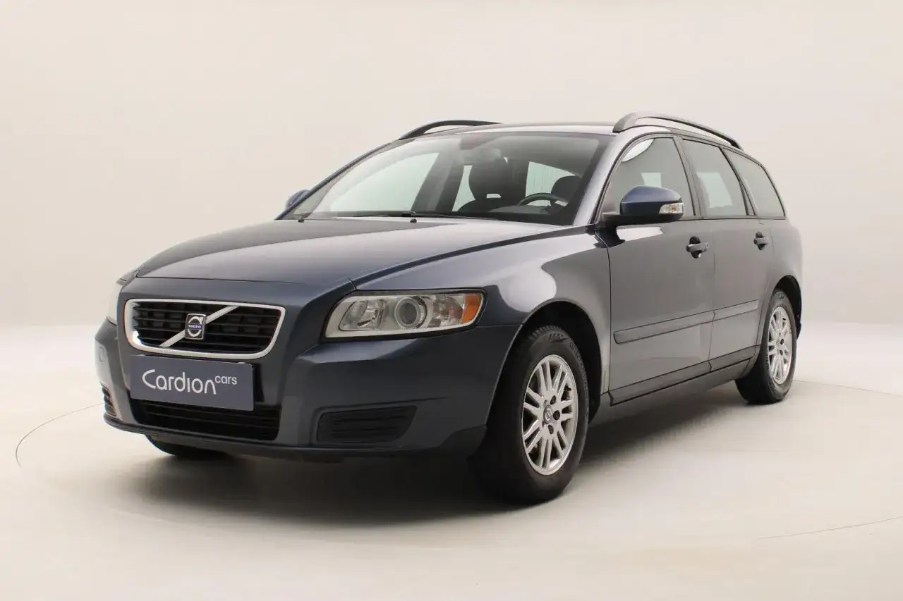 Ciemnogranatowe Volvo V50 1.6 diesel, kombi, z relingami dachowymi, na białym tle.