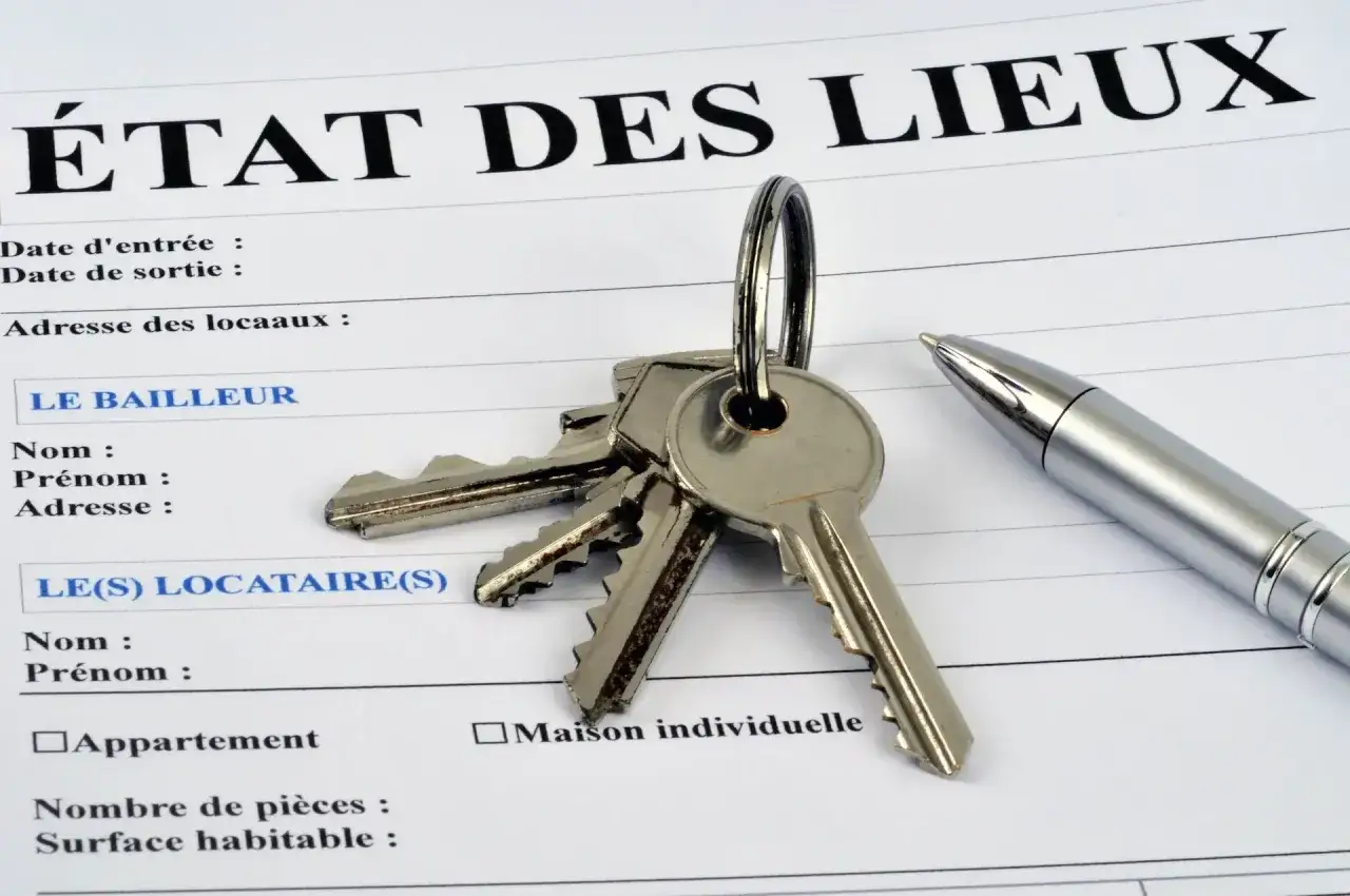 Un trousseau de clés et un stylo sur un état des lieux, prêt pour l'encaissement du chèque de caution.