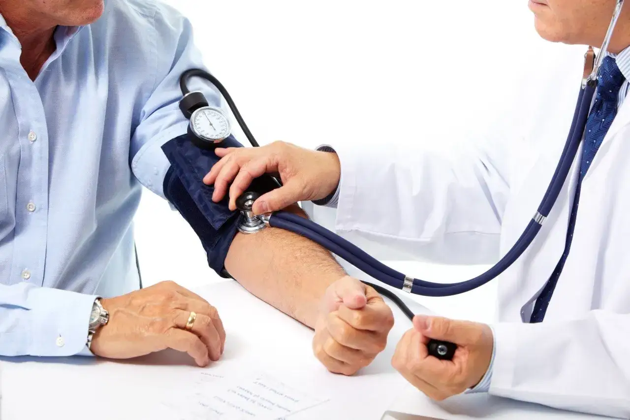 Lekarz mierzy ciśnienie pacjentowi. Wynik wskazuje niskie ciśnienie i niski puls, co wymaga dalszej diagnostyki.