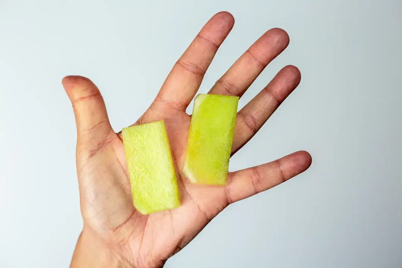 Zwei gr&uuml;ne Honigmelone-Baby-St&uuml;cke liegen in einer Hand.