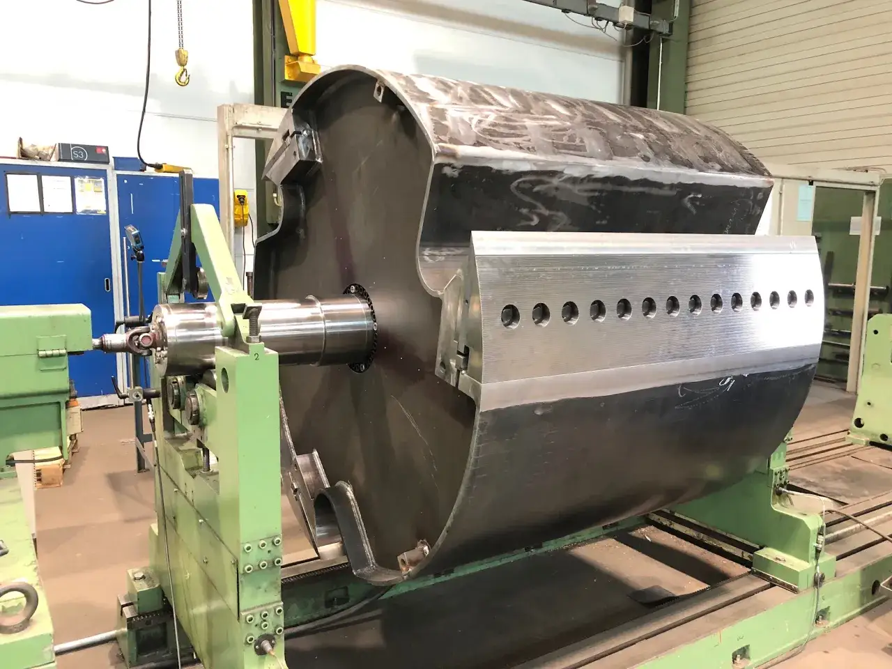 Gro&szlig;er Zylinder auf einer Maschine f&uuml;r dynamisches auswuchten. Die Maschine ist gr&uuml;n, der Zylinder ist metallisch und hat Schwei&szlig;n&auml;hte.