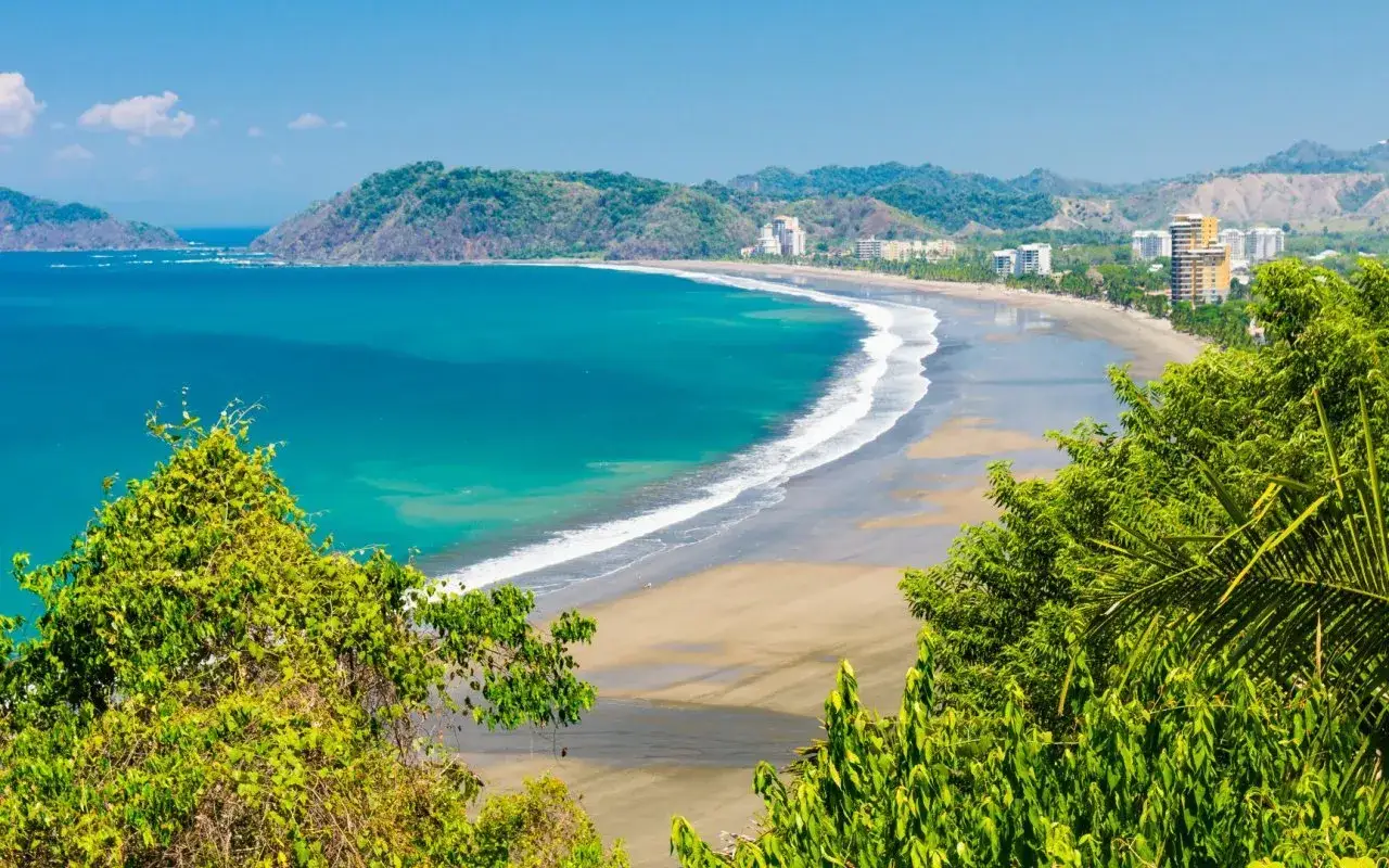 Traumhafter costa rica strand mit t&uuml;rkisfarbenem Meer, sanften Wellen und gr&uuml;nen H&uuml;geln im Hintergrund.