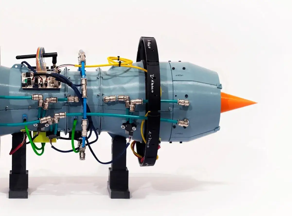 A 3D printed aerospace engine prototype, showcasing intricate plumbing and electronics, hinting at future innovations.