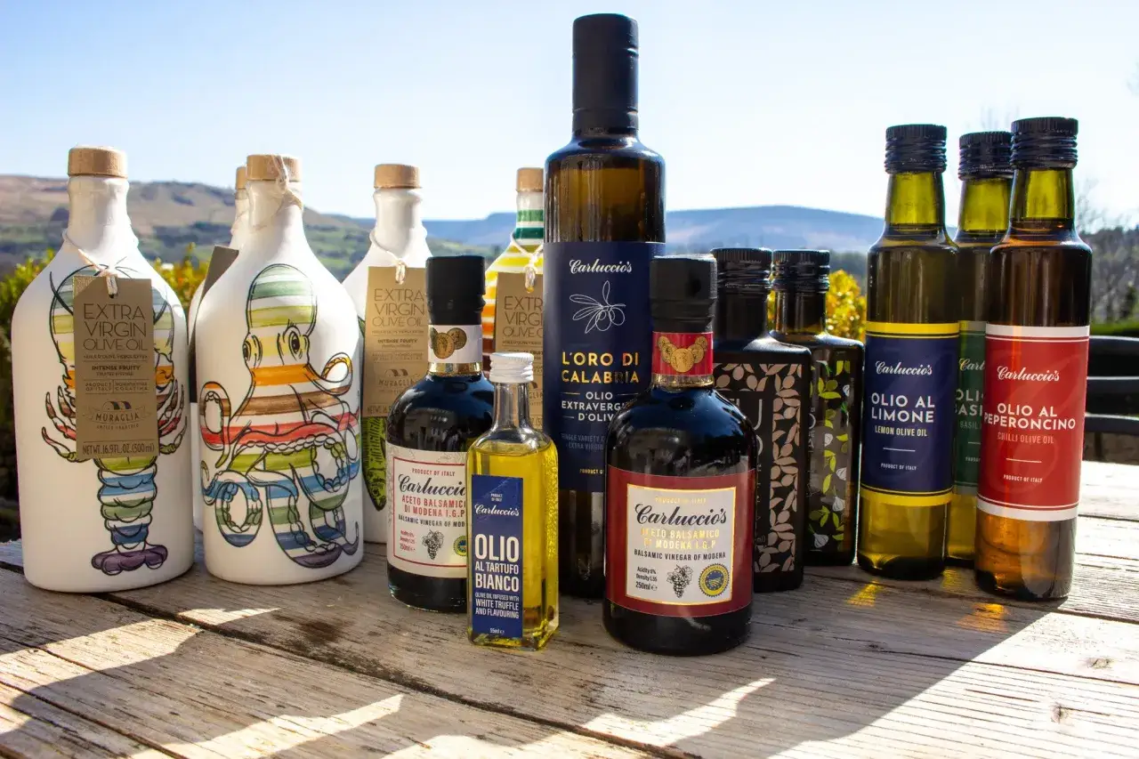 En samling flaskor med olivolja och balsamvin&auml;ger, d&auml;r olivolja nyttigt framh&auml;vs. Vackra flaskor med italienska etiketter och en liten flaska med vit tryffelolja.