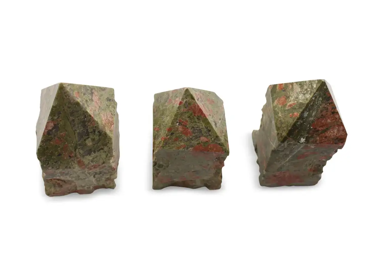 Drei facettierte Unakit-Kristalle mit Epidot-Einschlüssen, die wie kleine Pyramiden aussehen.