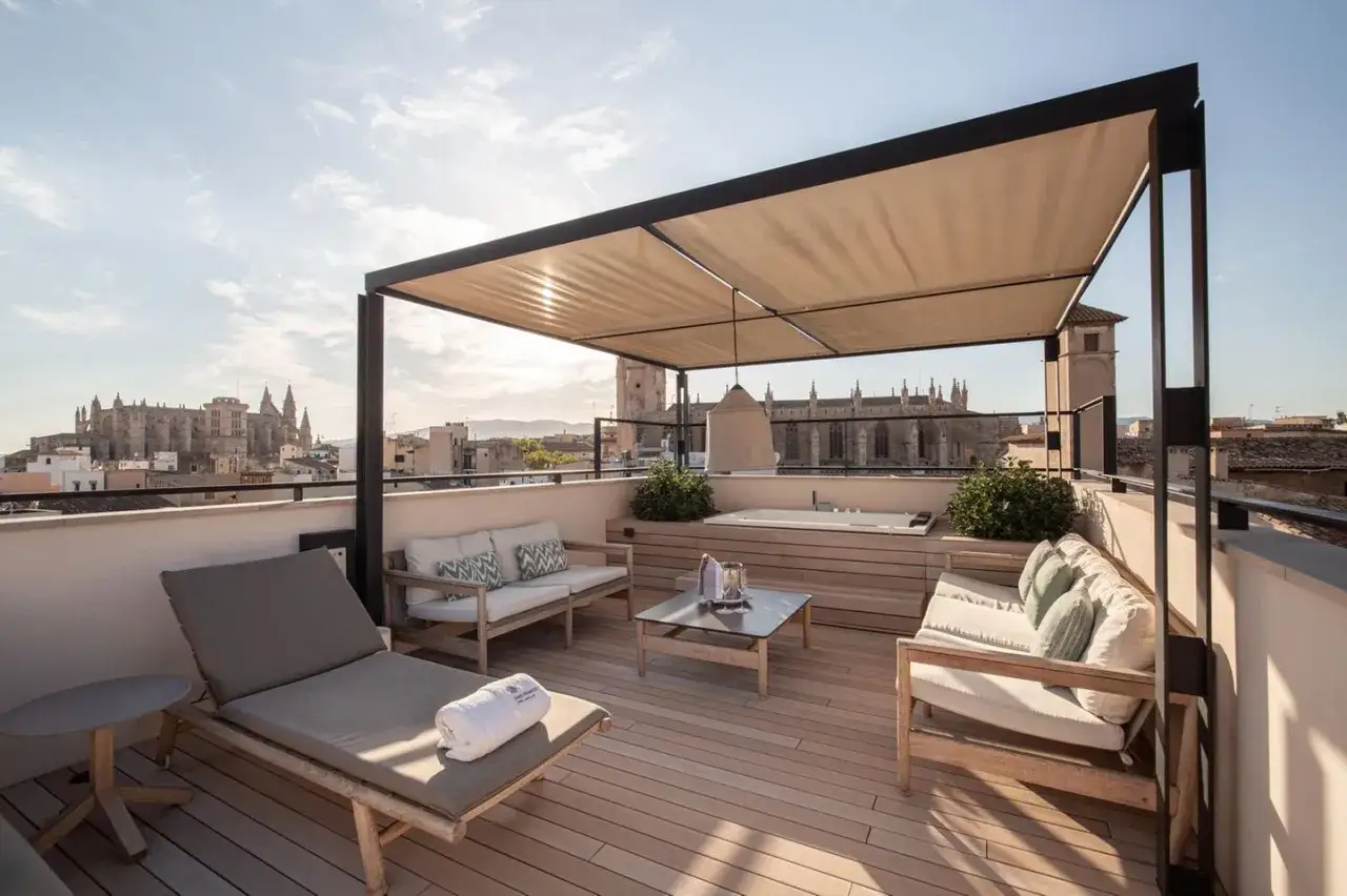 Luxuriöse Dachterrasse mit Whirlpool und Sitzgelegenheiten, tolle WPC Terrasse Ideen mit Blick auf eine Kathedrale.