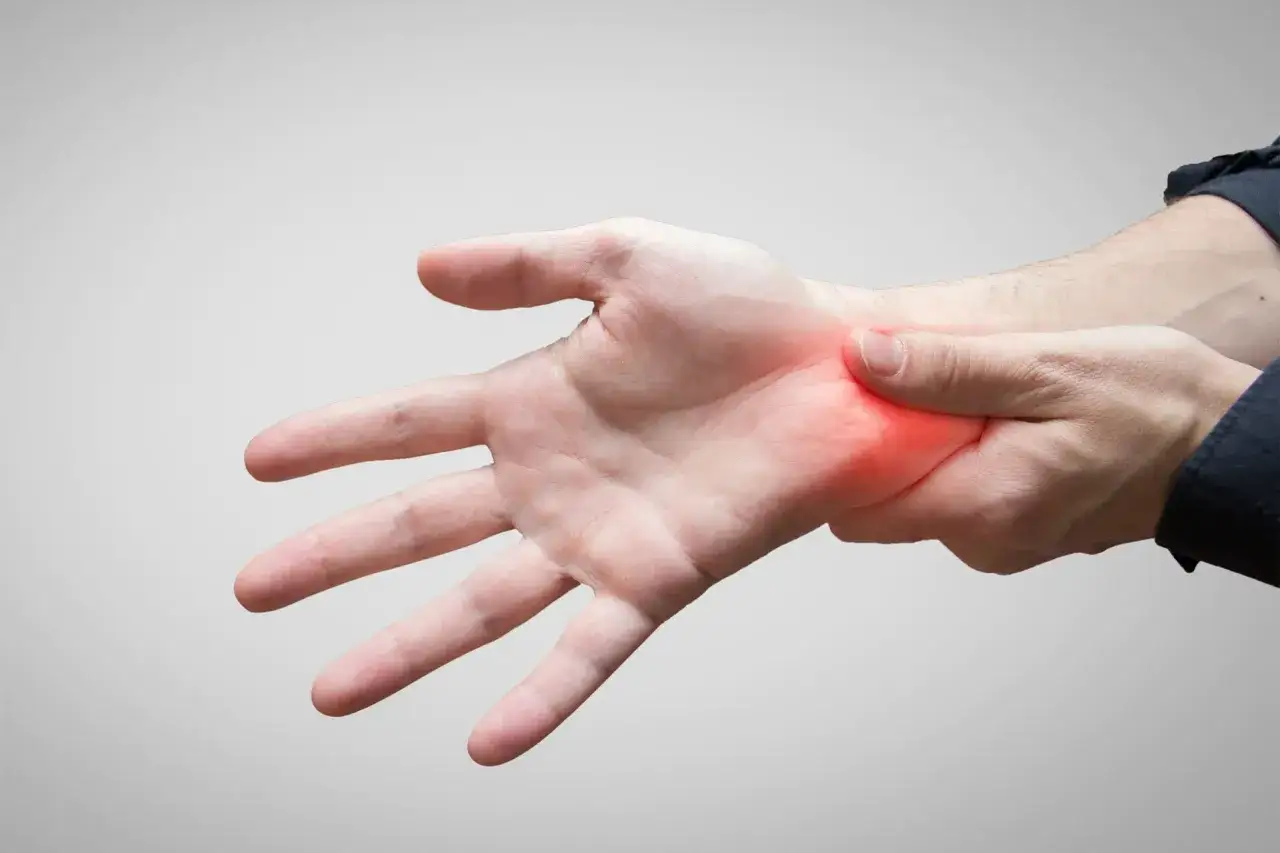 Mano con dolore al polso, possibile sindrome del tunnel carpale. Valutare se usare ghiaccio o calore per alleviare il fastidio.