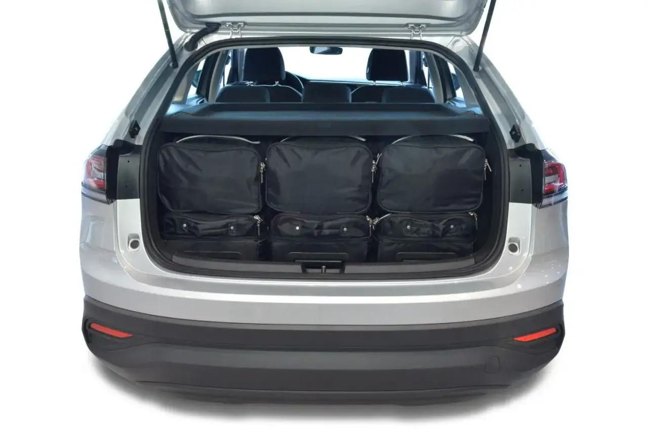 Bagageutrymmet i en VW Taigo är fullpackat med sex svarta väskor, redo för en resa.