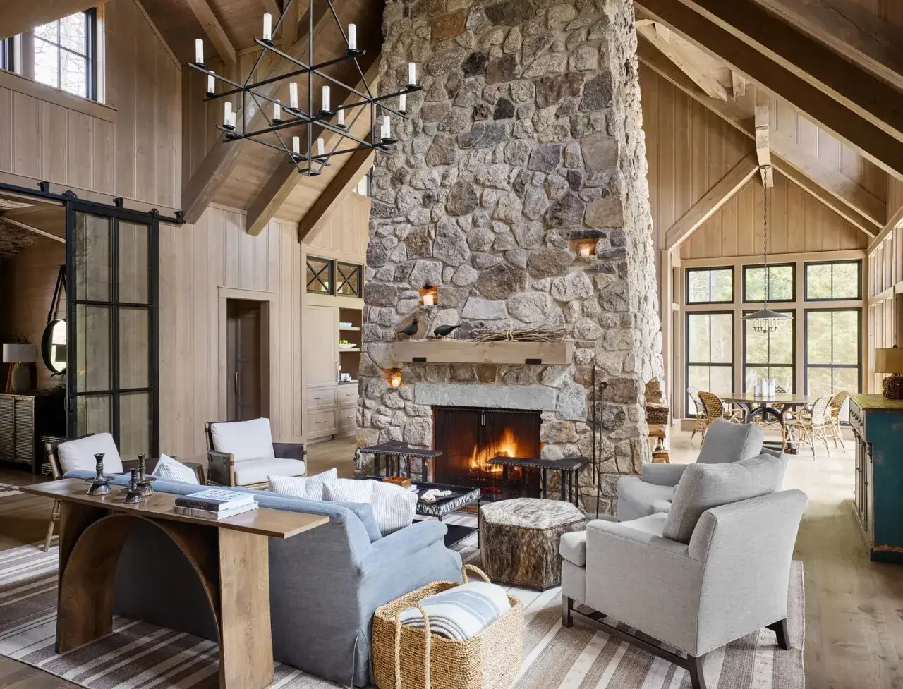 Cozy living room with a large stone fireplace, comfortable seating, and natural wood accents. This space offers inspiration on how to decorate a room for warmth and relaxation.