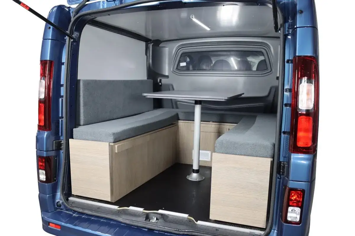Am&eacute;nagement int&eacute;rieur d'un Ford Transit Custom am&eacute;nag&eacute; en camping-car, avec banquettes, table et rangements. Avis Ford Transit Custom.
