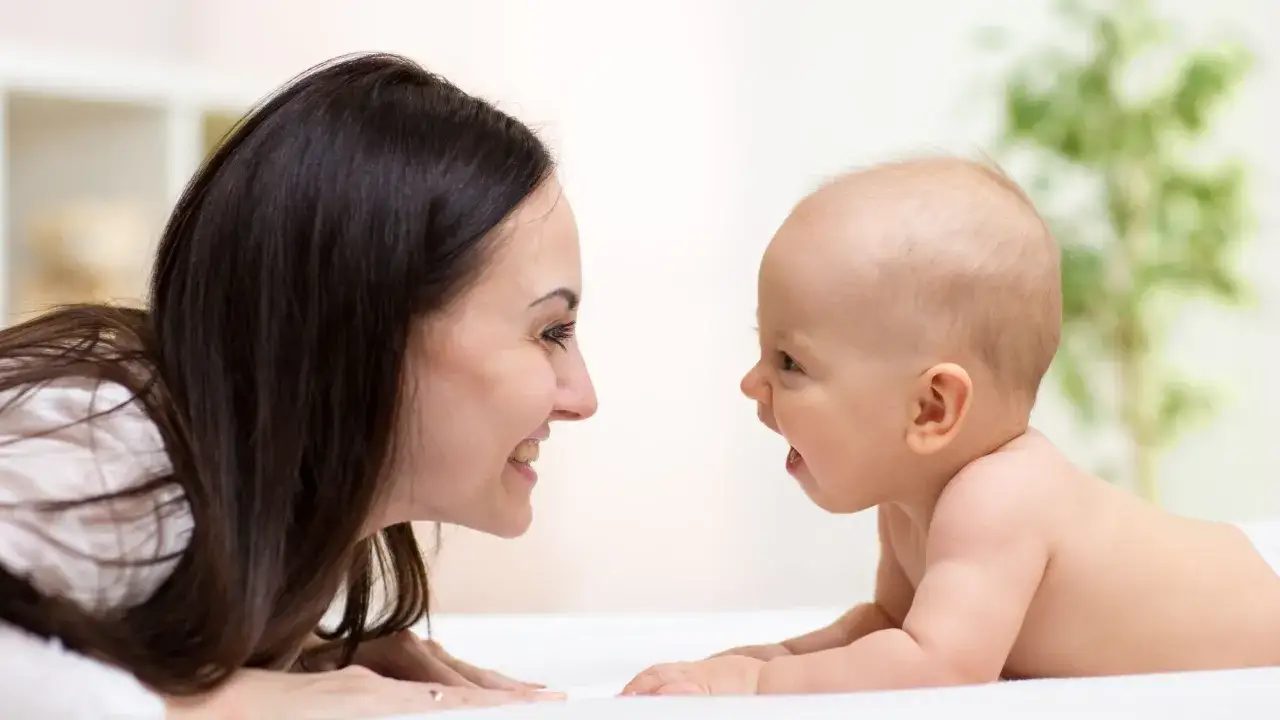 Mama i dziecko patrzą na siebie z uśmiechem. To piękny moment, kiedy dziecko rozpoznaje twarze bliskich.