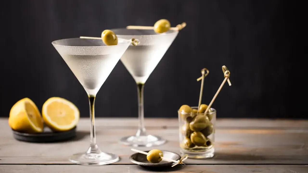 Tv&aring; frostiga martiniglas med oliver och citronklyftor. En perfekt dry martini recept-inspiration.