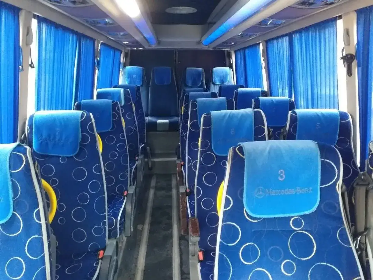Wnętrze autobusu na trasie Tirana-Durrës. Siedzenia Mercedes-Benz w niebieskie kółka, zasłony i oświetlenie.
