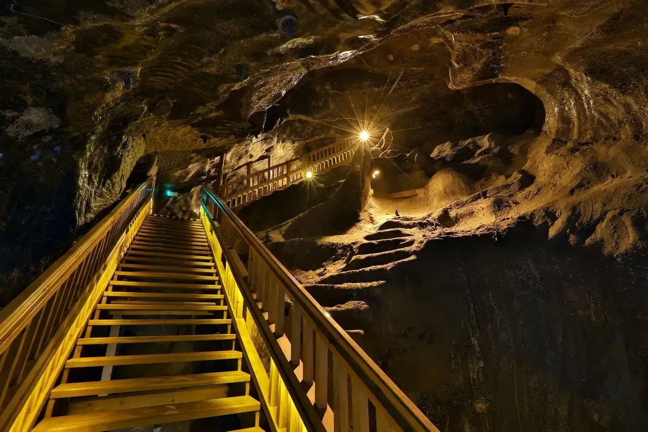 Drewniane schody prowadzą w głąb kopalni soli Wieliczka. Zdjęcia z tego miejsca ukazują niezwykłe podziemne krajobrazy.