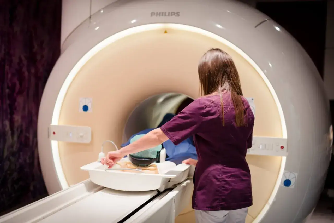 Technik przygotowuje pacjenta do badania rezonansem z kontrastem w nowoczesnym gabinecie diagnostycznym.
