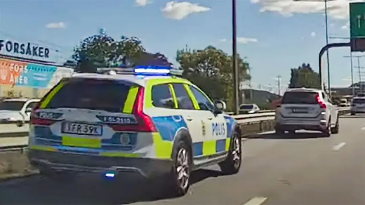 Svensk polisbil, en Volvo XC60, kör på motorvägen med blåljus på.