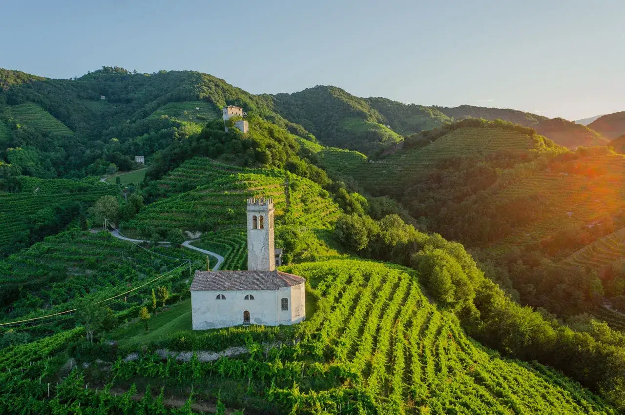 Chiesetta e vigneti a terrazze sulle colline del Prosecco, un luogo incantevole da esplorare.