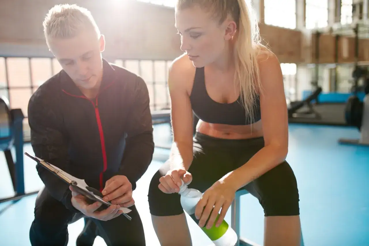 Trainer bespricht mit Athletin Trainingsplan. Informiere dich über die leistungsdiagnostik kosten für dein individuelles Training.