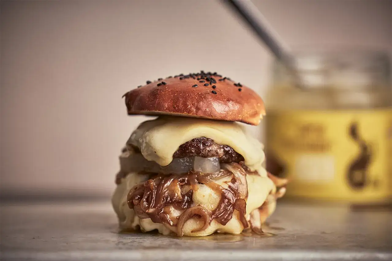 En saftig smashed burger med smält ost och karamelliserad lök. En härlig syn för alla hamburgareälskare.