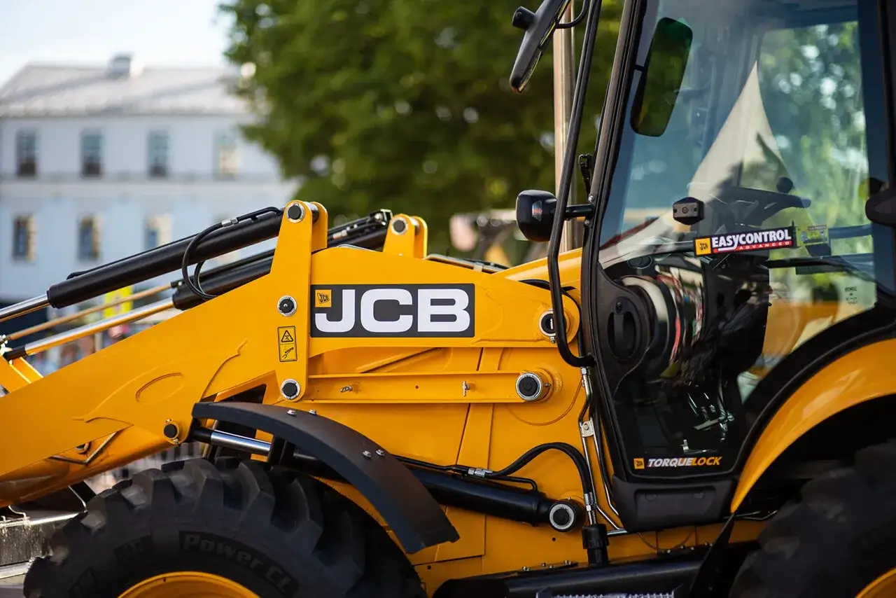 Szukasz koparko ładowarki do 30 tys.? Zobacz ten żółty JCB z bliska, z potężnymi oponami i hydraulicznym ramieniem.