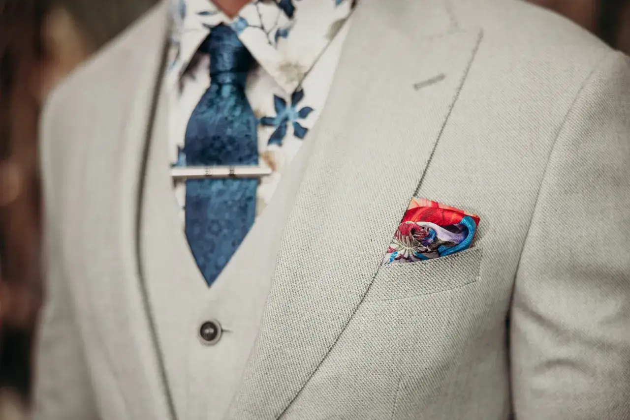 Elegancki, jasnoszary garnitur ślubny z wzorzystą koszulą i granatowym krawatem. Jak dobrać garnitur ślubny żeby służył na więcej niż jedną okazję?