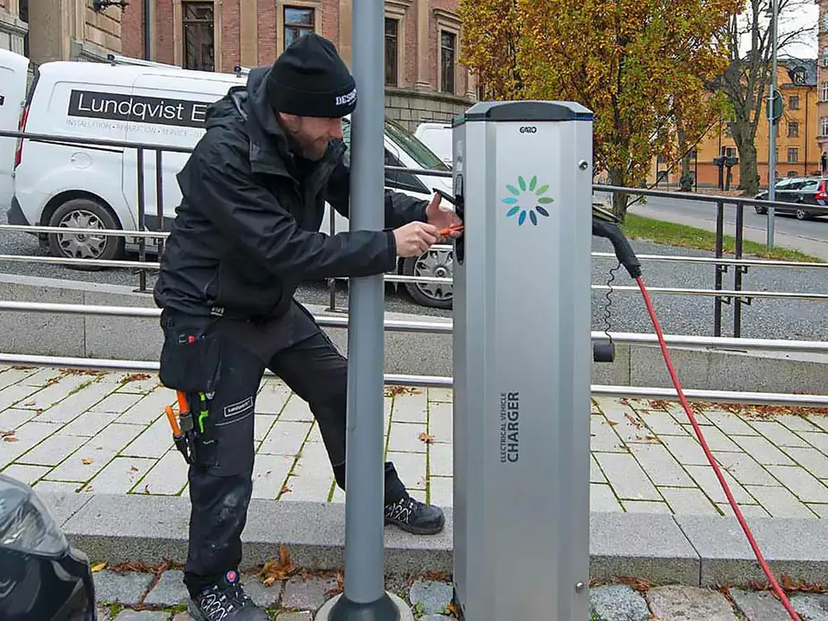 Tekniker installerar en laddstation f&ouml;r elbilar med energisk lastbalansering via wifi.