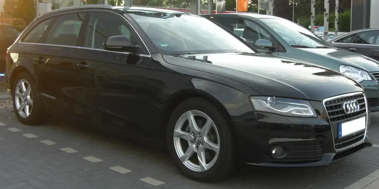 Schwarzer Audi A4 Avant 2008 mit silbernen Felgen steht auf einem gepflasterten Parkplatz.