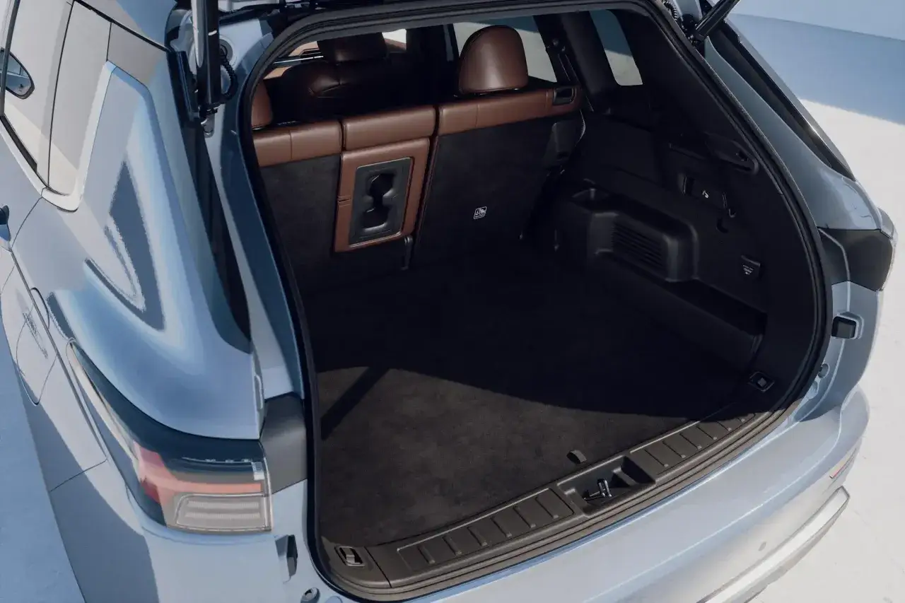 Przestronny bagażnik Mitsubishi Outlander PHEV z brązowymi skórzanymi siedzeniami w tle. Idealny na rodzinne wycieczki i zakupy.