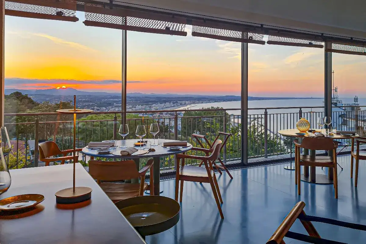 Tavoli apparecchiati con vista mozzafiato sul tramonto, un'esperienza culinaria indimenticabile in un gabicce monte ristorante stellato.
