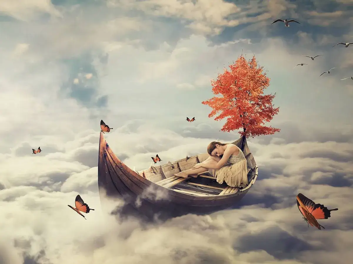 Una mujer duerme en un bote entre nubes, rodeada de mariposas y un &aacute;rbol oto&ntilde;al. Un escenario que parece sacado del diccionario de los sue&ntilde;os.