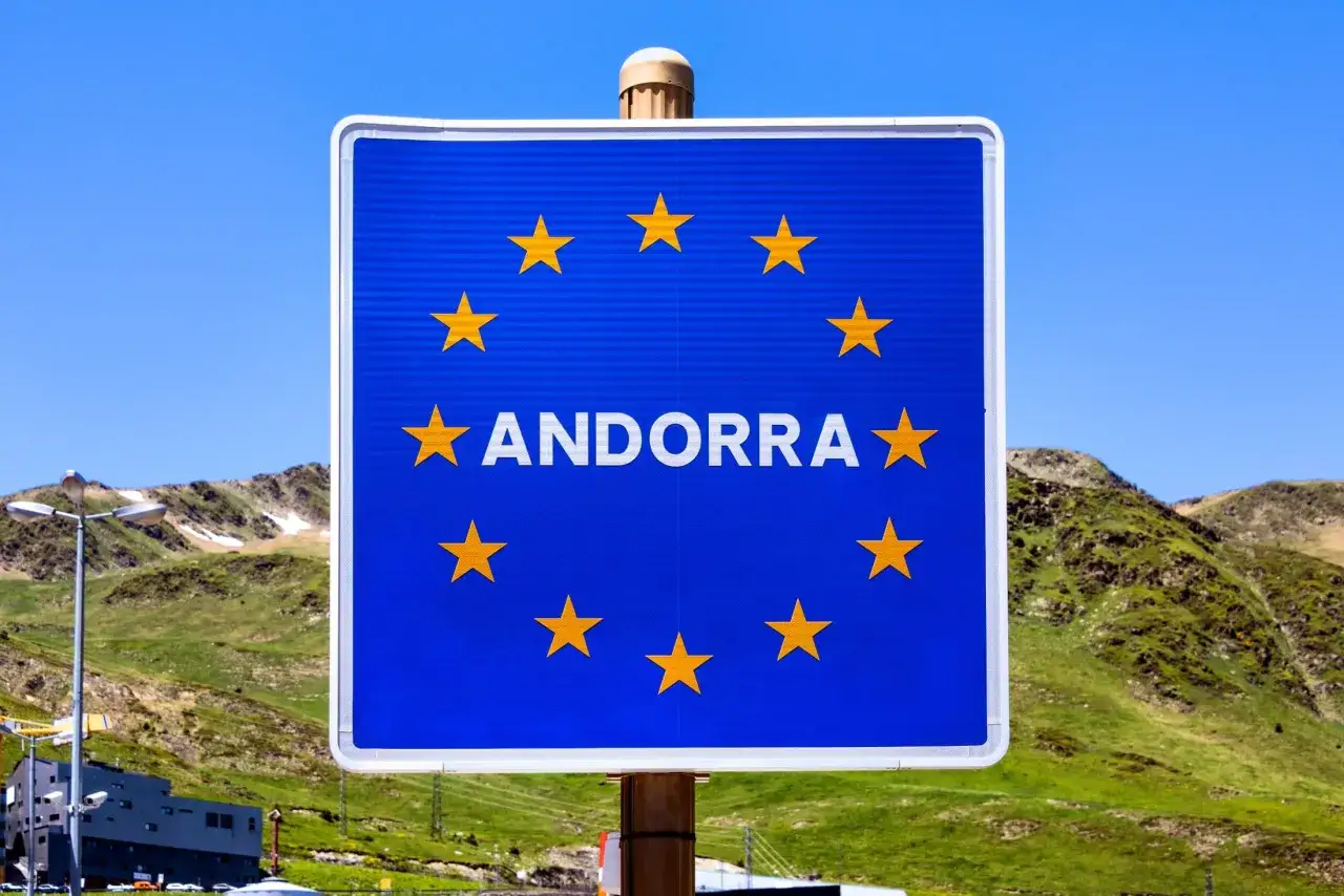 Znak graniczny Andory, kraju, który graniczy z Francją i Hiszpanią, na tle gór.