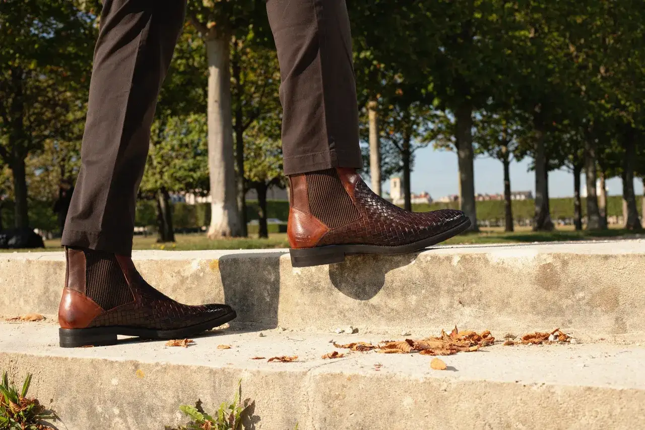 Eleganckie, brązowe botki z plecionej skóry to idealne buty do chinosów na jesienny spacer.
