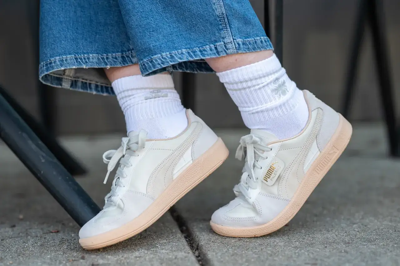 Wei&szlig;e Socken im Sneaker-Trend mit hellen Puma-Schuhen und Jeans.