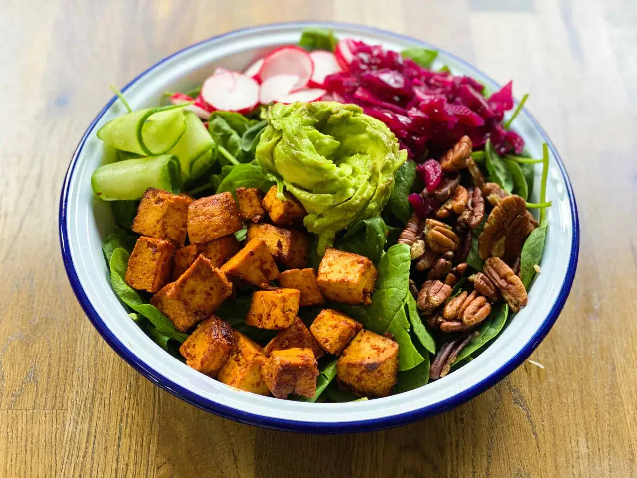 Kolorowa sałatka z pieczonymi kostkami tofu, awokado, rzodkiewką, og&oacute;rkiem i orzechami. Czy tofu można jeść na surowo? W tej wersji jest pieczone, ale można też pr&oacute;bować na zimno.