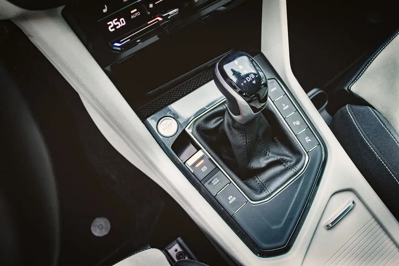 Manopola del cambio semiautomatico in un'auto moderna, con pulsanti per modalità di guida e freno di stazionamento.
